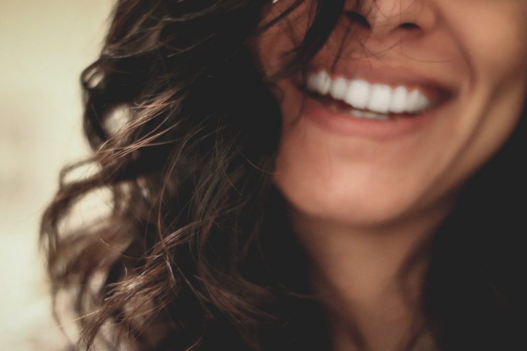 A close up of a woman's smile after dental implant surgery.